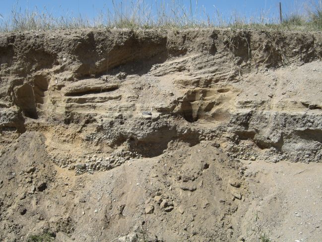  2006:09:11 00:48:17   NE BeachRdg1 - W side of gully - fluvial alluvial and pond seds - knife at contact between sandy pond seds and org-rich clayey sand at pond base.jpg